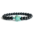 Close-up of matte black beads with a green turquoise sea turtle charm on elastic bracelet - Frosted Black Stone