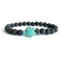 Macro detail of black lava stone beads with a turquoise sea turtle charm bracelet - Lava Stone