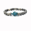 Close-up of beaded stretch bracelet featuring a turquoise turtle charm and marble beads - Map Stone
