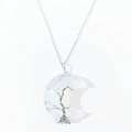 Detailed macro view of moon-shaped crystal pendant with wire wrapped tree of life design. - Opalite