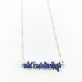 Detail of blue natural stone chips on a delicate gold chain necklace with minimalist style - Lapis Lazuli