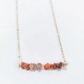Detail of irregular natural crystal stone pendant on a delicate gold link chain necklace - Red Agate