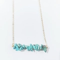 Macro shot of irregular turquoise stone beads on a delicate minimalist gold chain - Blue Turquoise