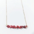 Close-up of natural red stone fragments on a minimalist gold chain necklace for women - Red Coral
