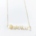 Close-up of irregular natural stone beads on a delicate gold link chain necklace - White Shell