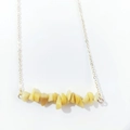 Macro view of natural yellow crystal stones on a delicate golden link chain necklace - Topaz