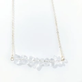 Macro shot of irregular natural white crystal stones on a minimalist gold-tone chain - White Crystal