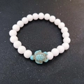 Elastic white beaded bracelet featuring a light blue sea turtle charm on a black background - White Stone