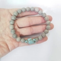 Handmade elastic beaded bracelet featuring grey wood grain beads and a blue turquoise turtle - Grey Wood Grain