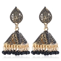 Detailed macro of vintage ethnic Jhumka earrings with golden metal and black beads - Black