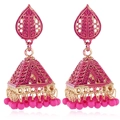 Detailed macro view of magenta enamel Jhumka earrings with golden floral hollow patterns - Pink