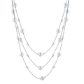 Three-layer faux pearl necklace with graduated white beads and black cord on white background - White