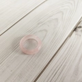 Top-down view of a 6mm minimalist translucent pink agate gemstone ring on wood - Rose Quartz