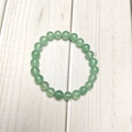 Detailed view of 8mm green aventurine beaded elastic bracelet on white wood texture - Green Aventurine