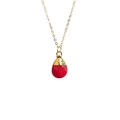 Macro detail of teardrop faceted red crystal pendant with gold plating on a fine chain - Red Jade