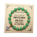 Detail von grünem Aventurin Armband mit Goldperlen und Evil-Eye-Anhänger auf Geschenkkarte - Aventurin-Jade