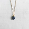 Macro detail of dark blue faceted teardrop crystal pendant with gold plating on fine chain - Lapis Lazuli