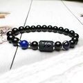 Dettaglio della perla Capricorno sul bracciale in pietra di sabbia blu e ossidiana - Leone / Perle da 8mm