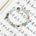 Yin Yang beaded bracelet with natural stones on calligraphy paper background - Amazonite
