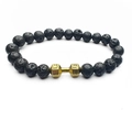 Detailed macro of black lava rock beads and golden dumbbell charm with engraved text - Lava Stone (Gold)
