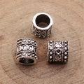 Tres cuentas espaciadoras de plata antigua con relieve infinito sobre fondo de madera - Plata antigua