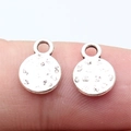 Hammered silver round metal charms on finger showing size and textured detail - Antique Silver