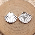 Vintage Silbermuschel-Anhänger für DIY-Schmuck auf rustikalem Holzscheiben-Hintergrund - Antiksilber