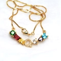 Close-up of golden letter Q pendant with multi-color gemstones and pavé zircon detailing - Golden Necklace A