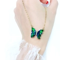 Detail showing gradient green and blue crystal butterfly necklace on skin with gold chain - Green AB Color