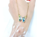 Close-up of a gold necklace featuring an iridescent butterfly pendant with sparkling rhinestones - White AB