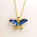 Nahaufnahme von goldenem Schmetterlingsanhänger mit blauen Kristallen und Zirkonia - Saphirblau