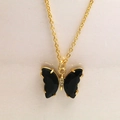 Détail d'un pendentif papillon doré avec des ailes noires facettées et des strass - Collier / Noir