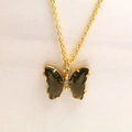 Gros plan détaillé du pendentif papillon doré avec des ailes en cristal vert brillant - Collier / Vert olive