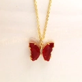 Vue détaillée d'un pendentif papillon en cristal rouge avec zircons sur chaîne dorée - Collier / Rouge