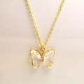 Détail d'un collier papillon doré avec des ailes en cristal facetté et une chaîne fine - Collier / Blanc