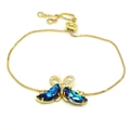 Detail eines verstellbaren Goldarmbands mit türkisem Kristallschmetterling Anhänger - Armband / Saphirblau