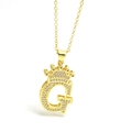 Macro shot of gold letter G pendant with crown design and shimmering zircon stones - Gold - Letter G