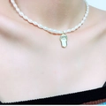 Detailopname van een parelketting met een goudkleurige strass slipperhanger om de nek - Enkellaags Parel Pantoffel Stijl (2#)