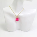 Détail du collier avec pendentif tasse à café rose rouge sur chaîne dorée sur un buste - Or Rose