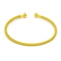 Dettaglio macro del bracciale rigido dorato a forma di C con trama a rete e sfere finali - Maglia Dorata (6#)