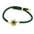 Detail of green woven bracelet with gold smiley face flower pendant and zircon stones - Dark Green Braided Smiley (B6)