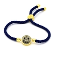 Macro detail of navy braided rope bracelet with a gold smiley face zircon charm - Dark Blue Braided Smiley (A4)