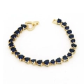 Detail eines herzförmigen blauen Zirkon-Tennisarmbands mit Goldbeschichtung und Verschluss - Armband / Blau
