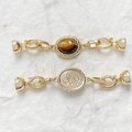 Dettaglio di chiusure per gioielli placcate oro 18k con occhio di tigre e rilievo floreale - Stile Occhio di Tigre Oro 18K