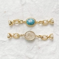 Macro-opname van 18k vergulde sluiting met turquoise inleg en vlinder reliëf detail - Vlinder Reliëf Stijl / 18K Goud Synthetisch Turquoise Stijl