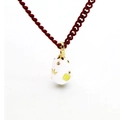 Detail of white enamel egg pendant with gold crown motif on a red rope necklace chain - White Egg Gold Crown Red Rope Style (06)
