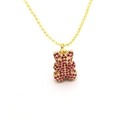 Detailaufnahme einer goldenen Kugelkette mit einem teddybär-anhänger und roten zirkonia - Fuchsia