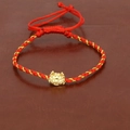 Macro view of braided red silk cord bracelet with a gold zodiac dragon charm and adjustable knot - Zodiac Dragon (A)