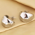 Detalle macro de pendientes geométricos de gota de plata con acabado metálico pulido - Estilo de Bloque Irregular / Oro blanco