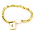 Detailed shot of golden bead bracelet featuring a baroque pearl and crescent moon charm - Moon